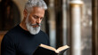 © demzp - Mature man with distinguished grey beard and mustache reading an old book indoors