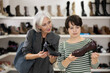 © JackF - Elderly and adult female customers purchases pair of classic shoes in shoe store
