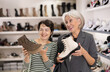 © JackF - Elderly female friend strongly recommends her young colleague to pay attention to contemporary model of chelsi boots made in light leather. Clients view boots with laces
