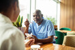 © Marko Geber - Healthcare worker eating lunch and using smartphone in cafe