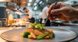 © Supriyadi - Chef Plating Gourmet Pan-Seared Salmon with Garnish and Vegetables in Commercial Kitchen