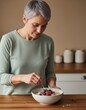 © Ryzhkov - Mature adult preparing a healthy breakfast bowl with oats and berries in a domestic kitchen for a wellness and nutrition focused lifestyle morning routine