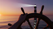 © Hammad - Nautical lighthouse at sunset with ship steering wheel, hand navigating boat towards beacon light, maritime guidance and leadership concept