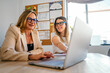 © karrastock - Businesswomen collaborating on laptop in modern office