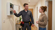 © Vika art - Professional male electrician explaining the fuse box panel to a female homeowner.
