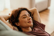 © La Famiglia - Woman relaxing at home finding peace and tranquility