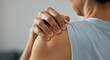 © eliyashevskiy - Close up of hands massaging a sore shoulder blade, shoulder pain symptom, photorealistic, shallow depth of field
