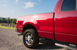 © Tetra Images - Red pickup truck on dirt road on sunny day