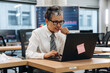© standret - Businesswoman with short gray hair is focused on laptop in modern office, surrounded by technology and data displays, illustrating workplace concentration and productivity