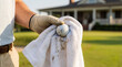 © Aurora Aesthetics - golf ball cleaning towel glove golf course clubhouse maintenance care closeup of a player wiping a ball after play ideal for equipment care sportsmanship tournament service and club lifestyle themes