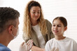 © New Africa - Endocrinologist in medical mask consulting woman with her daughter in clinic, closeup