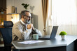 © Dejan - Mature man working on laptop in home office, joining an online meeting or video call, focusing on remote work
