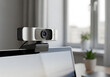 © Peahen - Modern webcam mounted on a laptop in a neutral home office setting. Device is positioned for video conferencing.