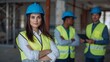 © NaesyaStudio - Confident female construction manager with arms crossed, leading a team of male workers on a modern building site, symbolizing progress and professional collaboration in engineering
