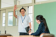 © buritora - A middle-aged male teacher in a polo shirt enters the classroom.
