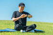 © buritora - A middle-aged man in sportswear uses a smartwatch and smart band to do yoga, stretching, and healthcare.