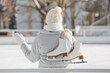© Pixel-Shot - Young woman with ice skates on rink, back view