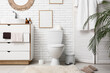 © Pixel-Shot - Interior of stylish bathroom with ceramic toilet bowl, sink and dresser