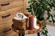 © Pixel-Shot - Burning candles with reed diffuser, basket and towels on table in bathroom, closeup
