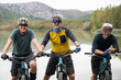 © .shock - Three friends mountain biking by a lake enjoying outdoor adventure and fitness together
