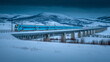 © BestFootageFirst - Passenger train traveling across elevated railway bridge in snowy landscape