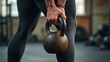 © rahwik - muscular woman holding old rusty kettlebell on gym floor focus on weight strength training concept