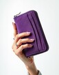 © Viktor - Woman holds purple suede wallet. Compact accessory features zip, card slots, and textured material. Offers stylish storage for money and cards.
