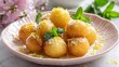 © fivan - Mini loukoumades soaked lightly in lemon-honey syrup and garnished with fresh mint leaves and grated lemon zest, arranged neatly on a pastel plate in bright spring window light