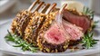 © fivan - Oven-roasted rack of lamb crusted with garlic and rosemary, sliced to reveal a juicy pink center and plated elegantly under bright spring lighting