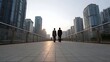 © Bussakon - Two professionals walk along a waterfront promenade at sunset symbolizing a new urban journey or career start