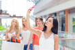 © alotofpeople - A girl shopping at the mall with three friends behind her