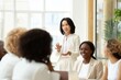 © Juan - Businesswoman presenting to coworkers in meeting showing leadership communication and collaborative workplace environment