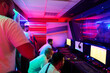© .shock - Esports Team Competing in Neon-Lit Gaming Room With Computers and Intense Focused Players