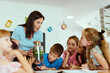 © .shock - Teacher showing a terrarium to curious elementary students during a hands-on classroom science lesson