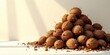 © Sumrit - A sunlit heap of dry, spiky seed pods and small brown nuts rests on a white surface