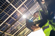 © ultramansk - Engineer in safety vest and helmet pointing towards a solar powered carport, illustrating eco-friendly innovation in parking infrastructure. Solar panels provide shade and sustainable energy.