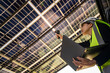 © ultramansk - Engineer in safety vest and helmet pointing towards a solar powered carport, illustrating eco-friendly innovation in parking infrastructure. Solar panels provide shade and sustainable energy.