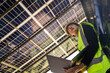© ultramansk - Engineer in safety vest and helmet pointing towards a solar powered carport, illustrating eco-friendly innovation in parking infrastructure. Solar panels provide shade and sustainable energy.