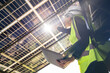 © ultramansk - Engineer in safety vest and helmet pointing towards a solar powered carport, illustrating eco-friendly innovation in parking infrastructure. Solar panels provide shade and sustainable energy.