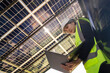 © ultramansk - Engineer in safety vest and helmet pointing towards a solar powered carport, illustrating eco-friendly innovation in parking infrastructure. Solar panels provide shade and sustainable energy.