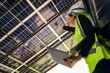 © ultramansk - Engineer in safety vest and helmet pointing towards a solar powered carport, illustrating eco-friendly innovation in parking infrastructure. Solar panels provide shade and sustainable energy.