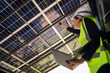 © ultramansk - Engineer in safety vest and helmet pointing towards a solar powered carport, illustrating eco-friendly innovation in parking infrastructure. Solar panels provide shade and sustainable energy.
