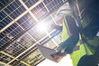 © ultramansk - Engineer in safety vest and helmet pointing towards a solar powered carport, illustrating eco-friendly innovation in parking infrastructure. Solar panels provide shade and sustainable energy.