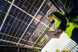 © ultramansk - Engineer in safety vest and helmet pointing towards a solar powered carport, illustrating eco-friendly innovation in parking infrastructure. Solar panels provide shade and sustainable energy.