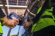© ultramansk - Engineer in safety vest and helmet pointing towards a solar powered carport, illustrating eco-friendly innovation in parking infrastructure. Solar panels provide shade and sustainable energy.