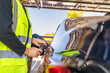 © ultramansk - Engineer in safety vest and helmet pointing towards a solar powered carport, illustrating eco-friendly innovation in parking infrastructure. Solar panels provide shade and sustainable energy.