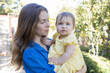 © Anna - happy young mother with her baby daughter. Happy Mother's Day. Tender maternal feelings. The joy of motherhood, tenderness, care, and soothing touches. Outdoor walks
