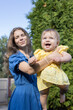 © Anna - woman lifts her baby daughter high in her arms, happily playing with her and enjoying the moment in nature at the park. The baby and mother are delighted.