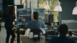 © DC Studio - System engineer checking code on multiple monitors and working with app developer colleague in it agency office. Coder analyzing algorithm on screens, developing new user interface.