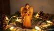 © CrazyJuke - Wooden Angel of Devotion: A finely crafted wooden angel figurine radiates a sense of peace and serenity, surrounded by soft light. The angel is positioned in a cozy scene of festive warmth.